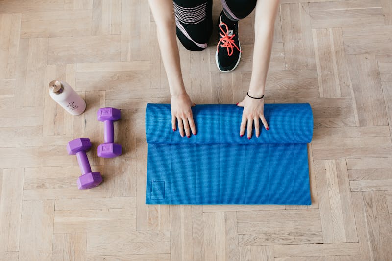 Lugn stretching-zon med foam rollers, mattor och dämpad belysning, växter i bakgrunden