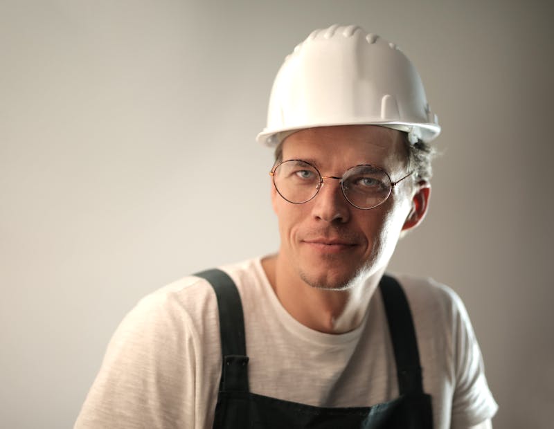Lars Lindström, man i 55-årsåldern med grått skägg och arbetskläder, skrattar framför en nyrenoverad dusch