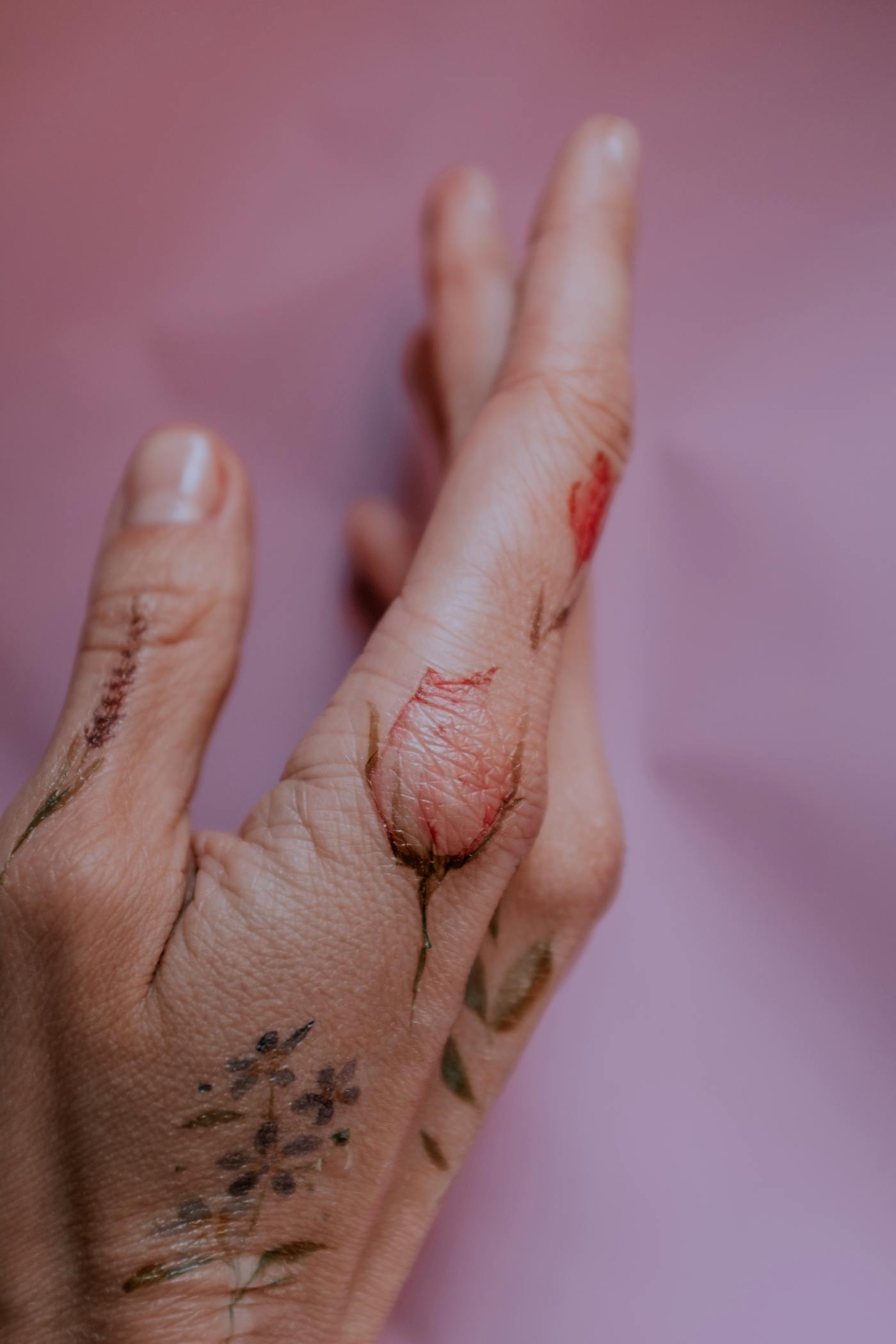 Minimalistisk tatuering av ett litet hjärta och initialer på ett finger, skarpa tunna linjer
