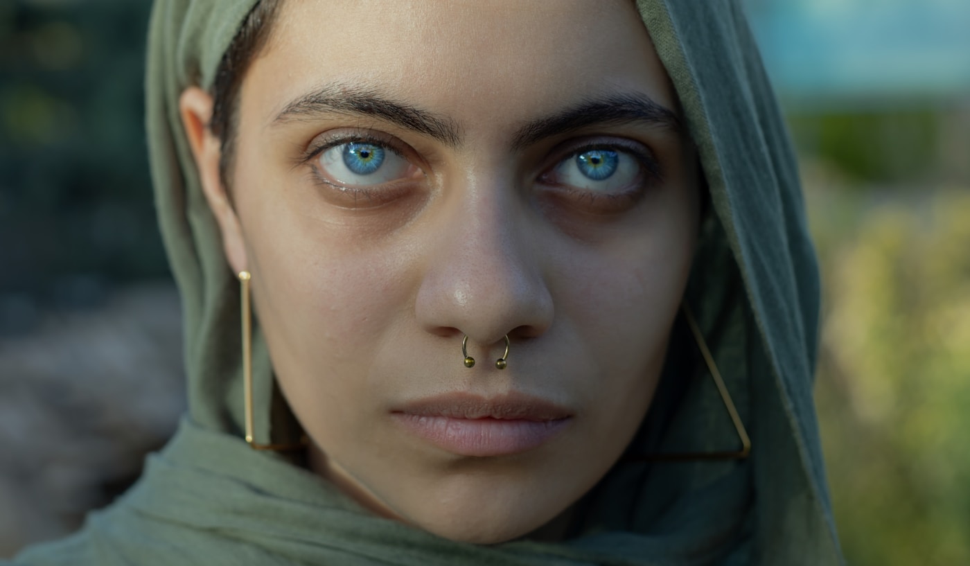 Septum-piercing i kirurgiskt stål på en kund som ler, professionellt fotograferad i studiobelysning